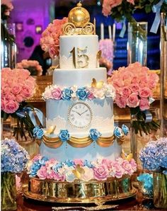 a three tiered cake decorated with pink and blue flowers