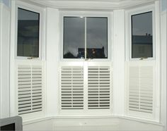 an empty bay window with white shutters