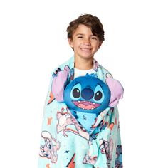 a young boy wearing a blue and pink blanket with an image of stitchy on it