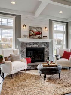 a living room with couches, chairs and a fire place in the middle of it