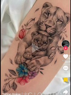 a tattoo with two lions and flowers on it