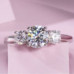 three stone diamond ring on pink background