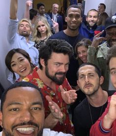 a group of people posing for a photo in front of the camera with their hands up