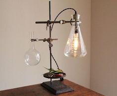 an old fashioned light fixture on top of a wooden table next to a glass bulb