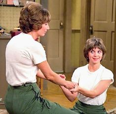 two women sitting on the floor with their hands together