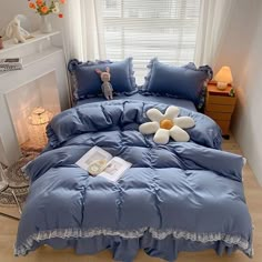 a bed with blue comforter and white flower on it