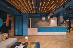 an office lobby with blue walls and wood flooring is pictured in this image from the front desk