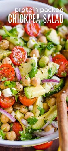 a salad with chickpea and tomatoes in a white bowl