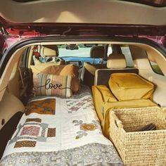 the back end of a car with its trunk open and bed in the passenger seat