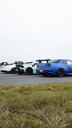 two cars are parked on the side of the road near each other in front of an airplane