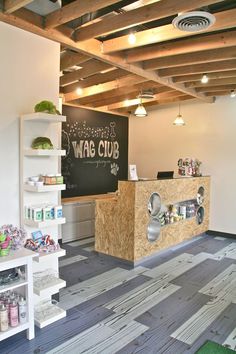 the inside of a wag club store with wood flooring and shelving units