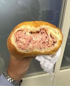 a person holding up a sandwich with meat in it