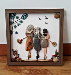 two dolls are holding hands in a shadow box