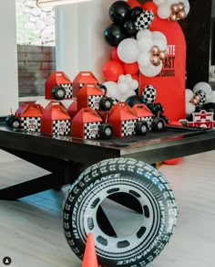 a table topped with lots of black and white balloons next to an orange traffic cone