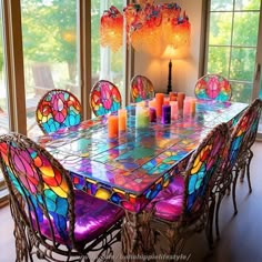 a dining room table with colorful stained glass chairs and chandelier hanging from the ceiling