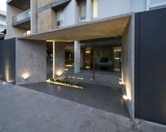 the entrance to an apartment building is lit up at night