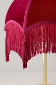 a pink table lamp with fringes on it