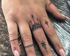 a woman's hand with two different tattoos on it and one has a crown