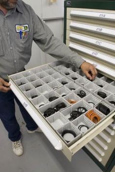 a man is holding a drawer full of wires