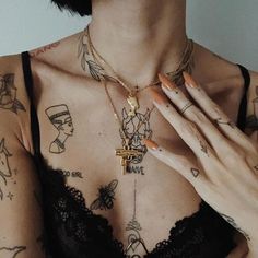 a woman with tattoos on her chest holding a cross