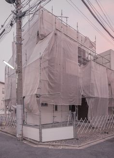 an old building covered in tarps and scaffolding on the side of the road