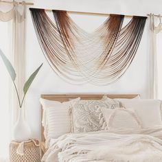 a bed with white sheets and pillows in a room