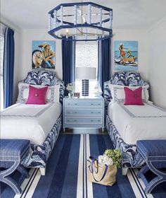 two beds in a room with blue and white decor on the walls, along with a striped rug