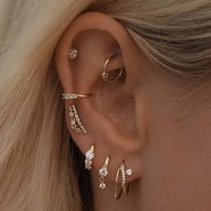 a woman's ear with three different types of piercings