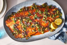 a plate with some fish and lemons on it