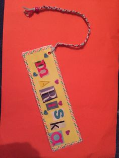 a red bag with the words happy birthday hanging from it's side on a table