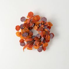 an orange and purple flower wreath on a white surface