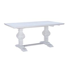 a white dining table with an ornate design on the top and base, against a white background