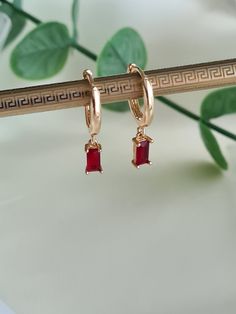 ❤Gorgeous little pair of Gold huggies handmade with a small red zircon  charm. ❤These long lasting 18K Gold plated huggies are 15mm in diameter and the red zircon rectangular charm just 8mm x 4mm.  ❤Hypoallergenic and great for sensitive ears. ❤Perfect earrings for everyday wear or that special occasion and will come with a lovely velvet pouch ready for gifting 🎁  Due to individual monitors colours may vary but please contact me with any queries. Thanks for checking out my etsy shop 🙂 Red Hoop Huggie Earrings, Trendy Cubic Zirconia Hoop Earrings For Gift, Dainty Red Dangle Jewelry, Charm Earrings In Cubic Zirconia As Gift, Trendy Cubic Zirconia Huggie Earrings As Gift, Red Huggie Earrings Gift, Red Huggie Earrings For Gift, Elegant Red Huggie Hoop Earrings, Dainty Red Earrings For Everyday