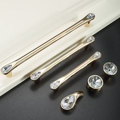 the handles and knobs of a white door are adorned with clear crystal stones in gold