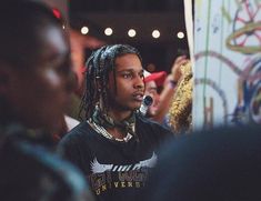 a man with dreadlocks standing in front of other people