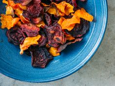 a blue bowl filled with dried fruit on top of a table