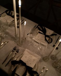 the table is set with silverware, candles and napkins for an elegant dinner