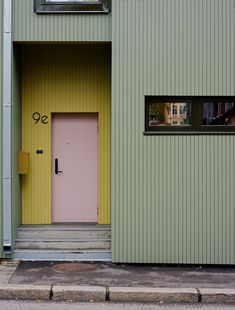 a green building with a pink door and window