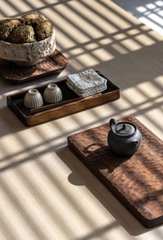 three tea trays on a table with two cups and one pot sitting on it