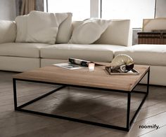 a coffee table sitting on top of a hard wood floor next to a white couch