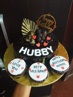 three cupcakes on a gold plate with the words hubby and best husband written on them