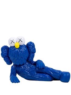 a blue figurine laying on its side with two eyes and one eye closed