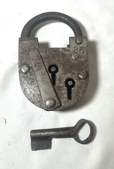 an old metal padlock with two keys and a key fobl attached to it