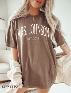 a woman with blonde hair wearing a brown t - shirt that says mrs johnson estt 2014