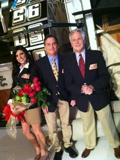 three people standing next to each other holding flowers