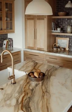 a kitchen with marble counter tops and wooden cabinets