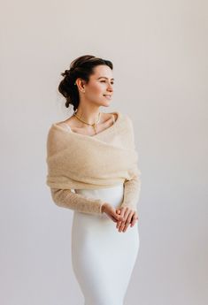 a woman in a white skirt and sweater posing for the camera with her hands on her hips