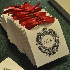 a stack of cards with red ribbons tied to them