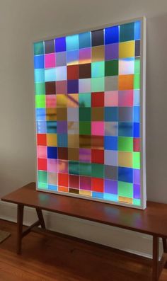 a large multicolored art piece sitting on top of a wooden table