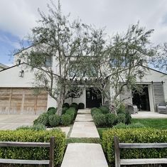 a large house with trees and bushes in front of the entrance to the yard area